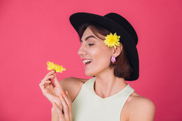 女人时尚的女人戴着帽子 微笑着两颗黄色的紫菀 春意盎然 快乐的情感与世隔绝颜色粉彩女性