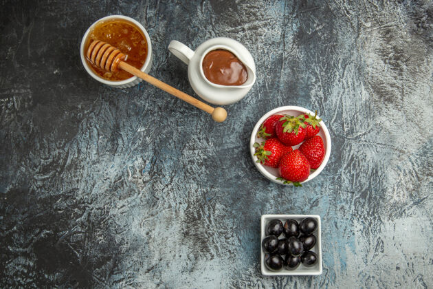 心脏顶视图新鲜草莓与橄榄和蜂蜜在黑暗的表面甜美的水果浆果新鲜草莓饮食浆果