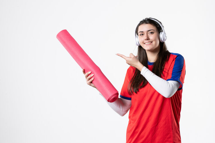 垫子正面图穿着运动服手持瑜伽垫的年轻女性漂亮视图保持