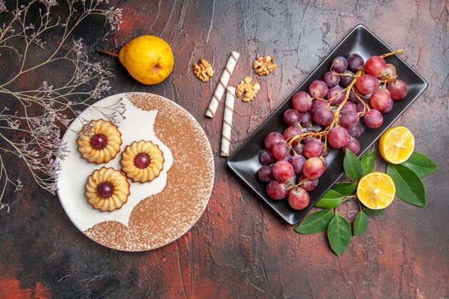 水果顶视图美味的小饼干 黑桌子上有葡萄 蛋糕甜饼干糖蛋糕多汁葡萄