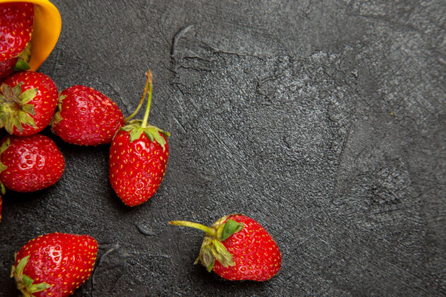 多汁顶视图黑色地板上新鲜的红色草莓果实成熟深色健康草莓