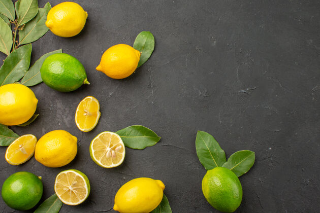 顶视图顶视图新鲜柠檬酸水果在黑暗的桌子上柑橘酸橙水果平铺水果健康