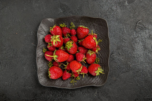 草莓顶视图新鲜的红色草莓在盘子里放在深色的水果浆果上盘子成熟甜点