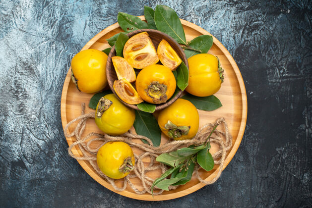 健康顶视图新鲜甜甜的柿子放在深色的桌子上成熟的水果洋葱味道成熟
