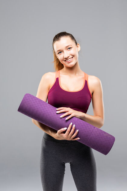 快乐运动型美女 健身课前后手拿瑜伽垫健身教练护理姿势