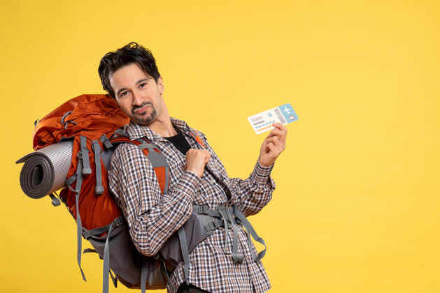 表情正面图年轻男子背着背包拿着黄色的车票旅行肖像假期