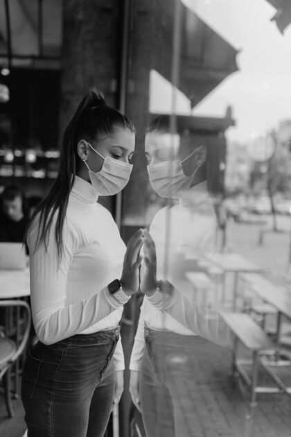 自助餐厅戴着面具的年轻女子站在咖啡馆的窗户前女人现代记忆