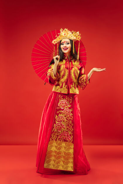 模特中国传统的优雅女子在红色的背景美丽的女孩穿着民族服装中国新年成人文化少数民族