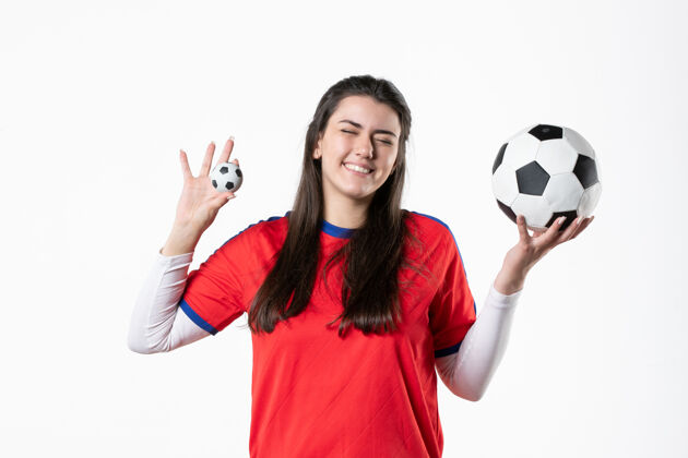 运动正面图微笑的年轻女子穿着运动服拿着足球足球女人运动