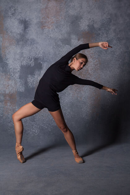 芭蕾舞演员年轻漂亮的现代风格舞者在灰色背景上摆姿势芭蕾技能灰色
