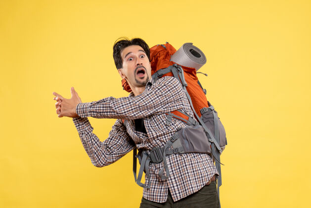 身高正面图：年轻的男性背着黄色的背包去远足音乐家乐器山