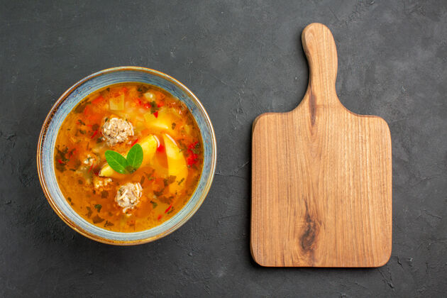 碗俯瞰美味的蔬菜汤配肉和土豆上深色的餐桌菜肉食胡萝卜食物顶