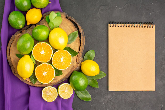 多汁在黑暗的餐桌上俯瞰新鲜的酸柠檬 柑橘和酸橙水果柑橘食物健康