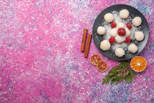 美味美味的椰子糖在粉红色表面盘子内俯视图闪亮盘子传统
