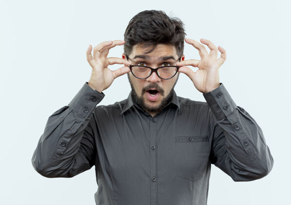 眼镜惊讶的年轻商人戴着眼镜抓起了眼镜上的白色隔离年轻人表情抓住