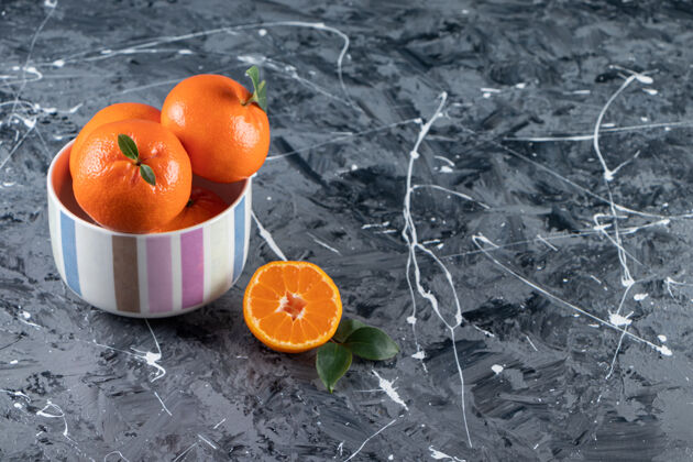 完美把新鲜的橙子切成薄片 叶子放在五颜六色的碗里橘子颜色水果