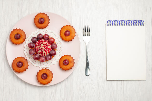 派俯瞰美味的蛋糕和葡萄在一张白色的桌子上饼干甜点馅饼食品装饰品顶部