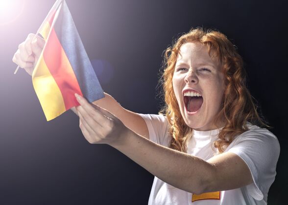 欢呼手持德国国旗的欢呼的女人德国国旗人水平