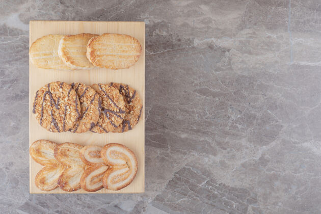 美味在大理石上的一块小木板上放着各种各样的饼干饼干口感美味