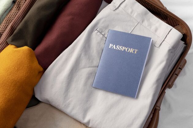 行李打开的行李和折叠的衣服和护照旅游顶视图度假