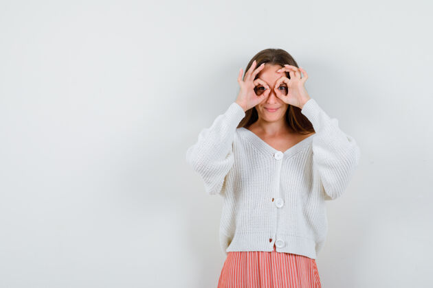 欢呼穿开衫的年轻女性展示眼镜姿势的肖像女人漂亮手势