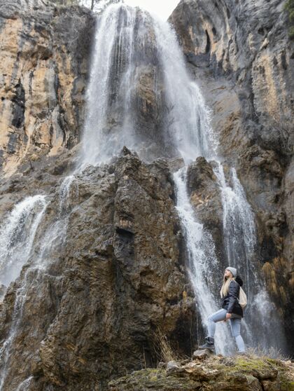 女人瀑布里的女人背包探索瀑布
