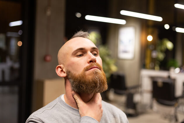 帅哥在理发店剪胡子的欧洲野蛮人年轻机器客户