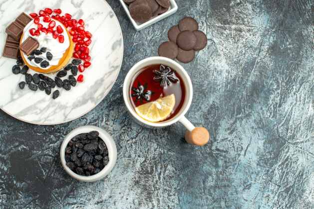 餐顶视图美味的奶油蛋糕与巧克力饼干和一杯茶在浅暗的背景盘子美味的奶油蛋糕糖