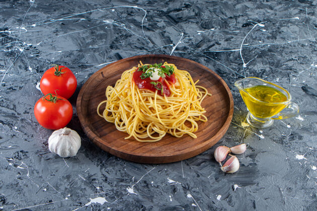 油在大理石表面放上美味的意大利面和番茄酱和蔬菜意大利面一餐大蒜