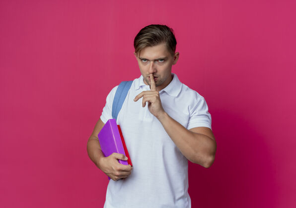 沉默年轻帅气的男生穿着书包背着书包手势粉色