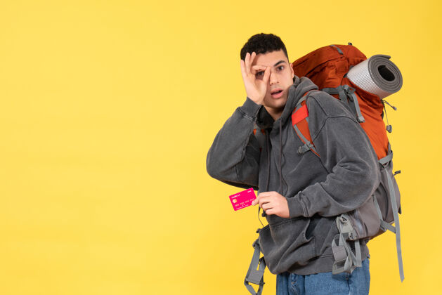 肖像正面图酷炫旅行男 背着红色背包 手里拿着折扣卡自信专业一件