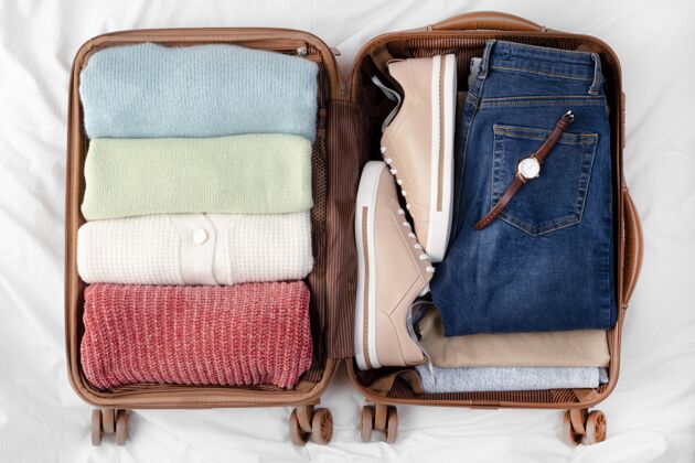 平面图打开的行李和折叠的衣服和鞋子衣服钟表旅行