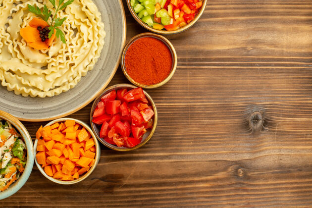 桌子顶视图生面团由蔬菜和调味品在棕色桌子上形成的生面团-生面团形式观点面食
