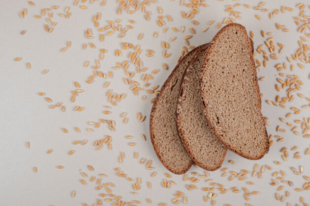 面包切片新鲜的棕色面包 白色表面有燕麦粒切片面包房食品
