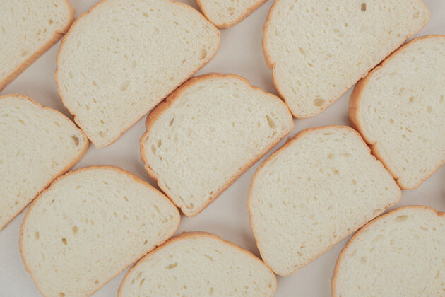 食品把新鲜的白面包片放在白色的表面上营养美味面包房