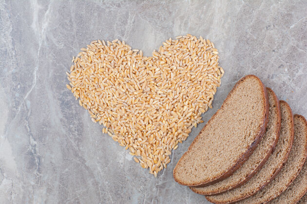 面包在大理石表面涂上燕麦粒的棕色面包片谷物棕色燕麦