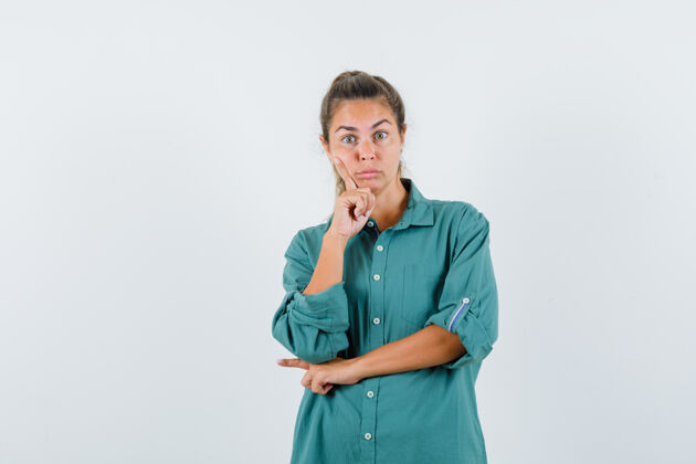 前面年轻女子穿着绿色上衣站在思考的姿势 看起来沉思女人衬衫肖像