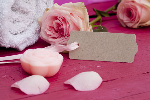 生日特写镜头的一个标签 美丽的粉红色玫瑰和蜡烛在粉红色的表面花自然爱