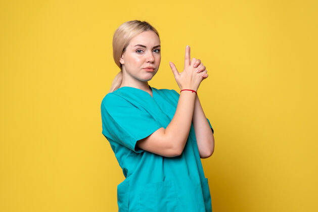 人前视图穿着医疗衬衫的女医生摆姿势 大流行护士医疗covid-19情感流行黄色姿势