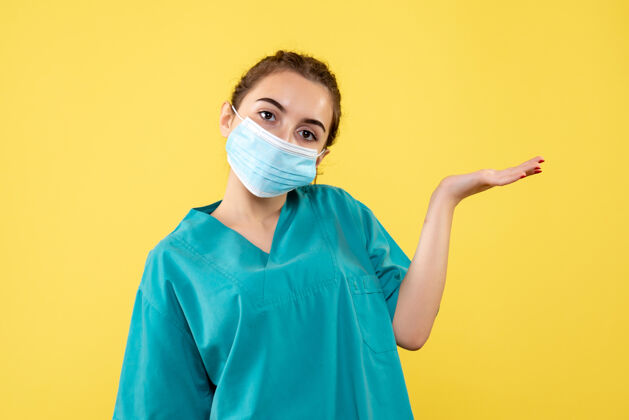 黄色正面图女医生穿着医用衬衫和无菌口罩 大流行色健康制服covid-19病毒面罩支持妇女