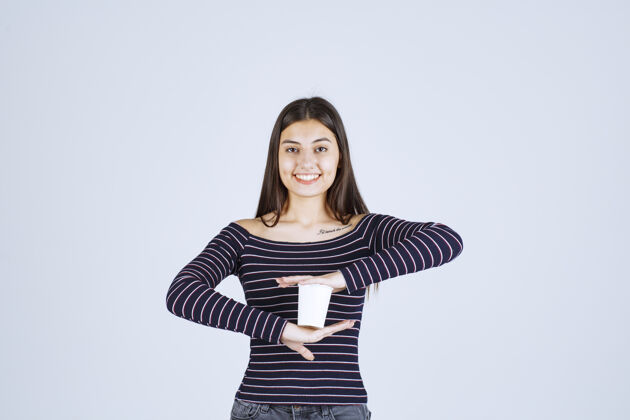 职员穿着条纹衬衫的女孩双手捧着一个塑料咖啡杯休闲人体模特服装