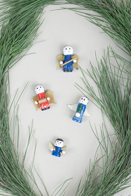 天使圣诞玩具和米色表面的树枝装饰品节日人物