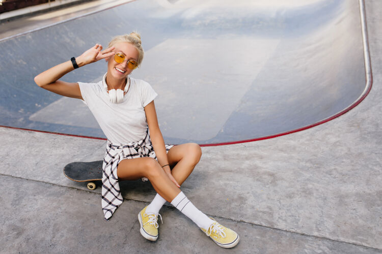 欢乐有趣的溜冰女 时尚的发型 表达积极的情绪溜冰公园里快乐的女模特的户外肖像滑板活动长板