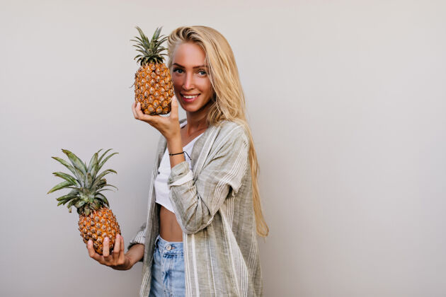 人长发女孩抱着菠萝 带着迷人的微笑白色女士在摄影棚摆着异国水果的姿势饮食休闲积极