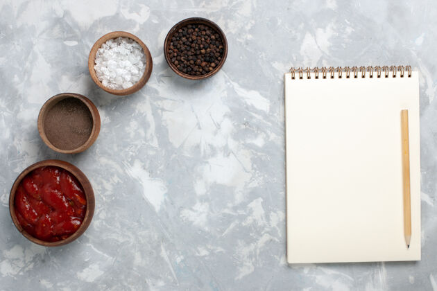 调味料顶视图不同的调味品与记事本上的白色笔记本酱汁黑板