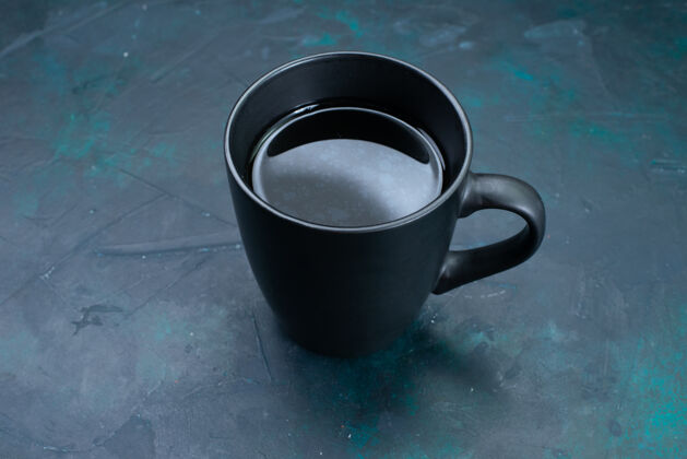 咖啡前视茶杯放在深蓝色桌上 茶饮颜色液体杯子桌子