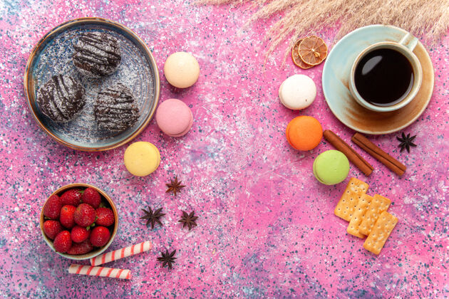 蛋糕俯瞰美味的巧克力蛋糕与法国马卡龙粉红水果食物杏仁饼