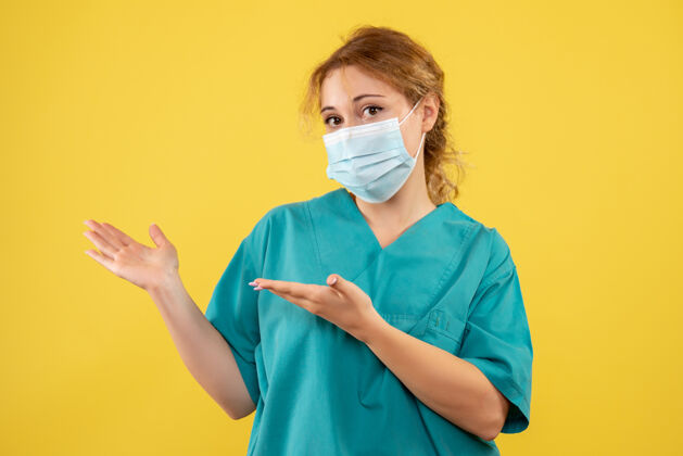 实验室外套黄墙上年轻女医生穿着医疗服 戴着口罩的正面图人肖像套装