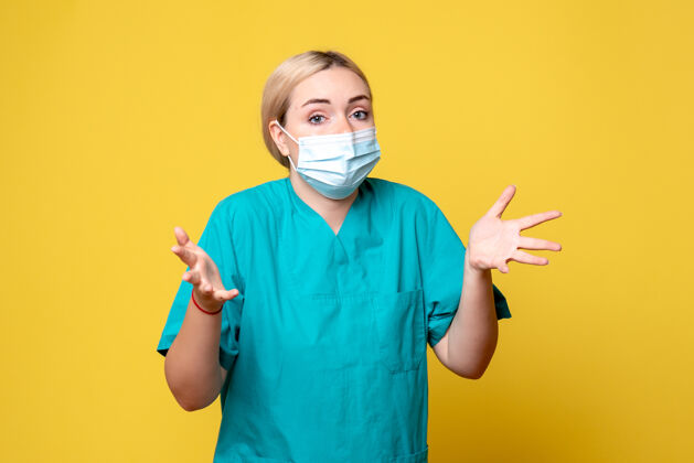 成人黄墙上年轻女医生穿着医用衬衫 戴着口罩的正面图医疗正面胡子