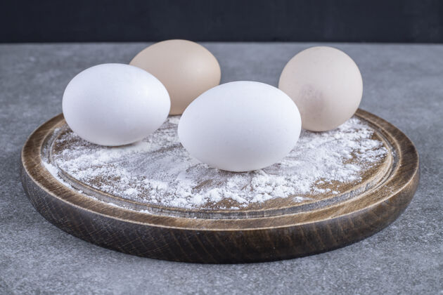 营养石桌上放着一盘白色和棕色的鸡蛋和面粉食品农场易碎